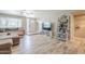 Bright living room featuring wood-look tile flooring, a large window, cozy sofa, and decorative shelving at 516 E Gemini Dr, Tempe, AZ 85283