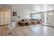 Open concept living room with wood-look tile flooring, large sectional sofa, and large windows at 516 E Gemini Dr, Tempe, AZ 85283