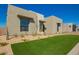 A modern home showcasing a clean design with a vibrant green lawn and desert landscaping at 5724 E Moura Dr, Cave Creek, AZ 85331