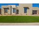 Modern home with neutral stucco, black framed windows, desert landscaping, and inviting green lawn at 5724 E Moura Dr, Cave Creek, AZ 85331