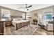 A calming bedroom featuring a wooden bed frame, ceiling fan, and natural light at 6523 S 34Th Dr, Phoenix, AZ 85041