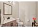 Clean powder room with a vessel sink, wood-look vanity, and neutral paint at 6523 S 34Th Dr, Phoenix, AZ 85041