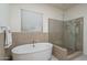 Elegant bathroom featuring a standalone tub and glass-enclosed shower at 7250 N 80Th Ln, Glendale, AZ 85303