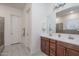 Bright bathroom with double sinks, wood cabinets, and tile floors at 7250 N 80Th Ln, Glendale, AZ 85303