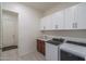 Well-lit laundry room featuring modern washer and dryer, ample cabinet space, and a sink for added convenience at 7250 N 80Th Ln, Glendale, AZ 85303