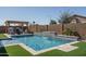 Swimming pool features stone accents and outdoor seating beneath a pergola at 7250 N 80Th Ln, Glendale, AZ 85303