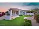 A home's backyard featuring artificial grass, desert landscaping, and an outdoor kitchen space at 7722 E Fledgling Dr, Scottsdale, AZ 85255