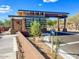 Community entrance with modern architecture, desert landscaping, and clear signage at 7722 E Fledgling Dr, Scottsdale, AZ 85255