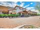 View of a shopping center with storefronts and outdoor dining areas, with parking in front at 7722 E Fledgling Dr, Scottsdale, AZ 85255