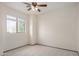 A cozy bedroom featuring carpet, a ceiling fan, and a window providing ample natural light and views at 833 W Cholla St, Casa Grande, AZ 85122