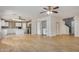 Open concept living space with laminate flooring, ceiling fans, and adjacent kitchen area, and laundry closet at 833 W Cholla St, Casa Grande, AZ 85122