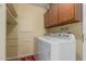 Well-lit laundry room features overhead cabinets, and washer and dryer at 9231 N 111Th Ave, Sun City, AZ 85351