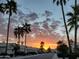 Beautiful sunset over a quiet neighborhood street lined with palm trees at 9296 E Karen Dr, Scottsdale, AZ 85260