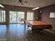 Well-lit game room with a pool table and views of the outdoor pool area through large windows at 10112 N 96Th Ave # A, Peoria, AZ 85345