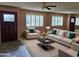 Bright living room featuring neutral furniture, a large window, decorative pillows, and a stylish coffee table at 10112 N 96Th Ave # A, Peoria, AZ 85345