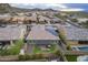 Aerial view of home with solar panels, covered patio, hot tub, desert landscaping, and mountain views at 10246 W Oberlin Way, Peoria, AZ 85383