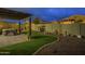 Well-maintained backyard boasts a pergola-covered patio, artificial turf, and low-maintenance desert landscaping for outdoor enjoyment at 10246 W Oberlin Way, Peoria, AZ 85383