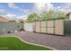 Well-maintained backyard with practical storage sheds and low-maintenance desert landscaping with artificial turf at 10246 W Oberlin Way, Peoria, AZ 85383