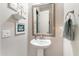 Bright bathroom featuring a pedestal sink, decorative mirror, and neutral wall decor and a towel ring at 10246 W Oberlin Way, Peoria, AZ 85383