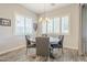 Cozy dining area features a rustic wood table and comfortable gray seating beneath modern lighting at 10246 W Oberlin Way, Peoria, AZ 85383