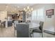 Bright dining area with a round wood table, gray upholstered chairs and modern chandelier at 10246 W Oberlin Way, Peoria, AZ 85383