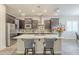 Bright kitchen featuring a large island with seating, stainless appliances, and dark wood cabinets at 10246 W Oberlin Way, Peoria, AZ 85383