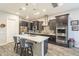 Stylish kitchen with a large island, modern lighting, stainless appliances, and dark wood cabinetry at 10246 W Oberlin Way, Peoria, AZ 85383
