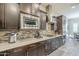 This stylish kitchen features dark wood cabinetry, stainless steel appliances, and gorgeous tile backsplash at 10246 W Oberlin Way, Peoria, AZ 85383