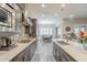 Open-concept kitchen with stainless steel appliances, dark cabinets, and seamless flow to dining area at 10246 W Oberlin Way, Peoria, AZ 85383