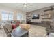 Cozy living room featuring a wood accent wall, comfortable seating, and natural light from the windows at 10246 W Oberlin Way, Peoria, AZ 85383