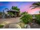 Landscaped backyard featuring a gazebo with seating, a fireplace, and custom lighting at 11336 N 117Th Way, Scottsdale, AZ 85259