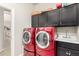 Efficient laundry room with front-load washer and dryer, ample storage, and a sink at 11336 N 117Th Way, Scottsdale, AZ 85259