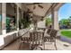 Charming covered patio with a stylish dining set, offering a serene view of the lush backyard and nearby grill area at 11336 N 117Th Way, Scottsdale, AZ 85259
