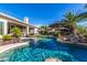 Sparkling pool surrounded by lush landscaping, a covered seating area, and mature palm trees at 11336 N 117Th Way, Scottsdale, AZ 85259