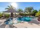 Stunning pool area with a rock waterfall, surrounded by lush greenery and shaded seating, perfect for relaxation at 11336 N 117Th Way, Scottsdale, AZ 85259