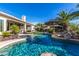 Sparkling blue pool surrounded by lush landscaping, including palm trees, and a covered outdoor seating area at 11336 N 117Th Way, Scottsdale, AZ 85259