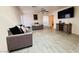 Open-concept living room with modern furnishings and wood-look tile flooring at 12046 W Scotts Dr, El Mirage, AZ 85335