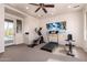 Brightly lit home gym featuring a ceiling fan, gym equipment, and views to the pool area at 12050 N Panorama Dr # 104, Fountain Hills, AZ 85268