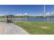 Picturesque park view featuring a lake with a fountain, a bench with shade, and green grass at 12050 N Panorama Dr # 104, Fountain Hills, AZ 85268