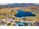 Scenic aerial view of a community pond with walking paths and mountain views at 12117 W Luxton Ln, Avondale, AZ 85323
