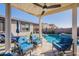 Inviting covered patio with plush blue seating overlooks a sparkling pool, perfect for outdoor relaxation at 12117 W Luxton Ln, Avondale, AZ 85323