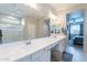 Bright bathroom with double vanity, white countertops, and a glass-enclosed shower for a spa-like feel at 12117 W Luxton Ln, Avondale, AZ 85323