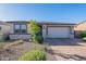 Charming single-story home featuring a stone facade, well-maintained landscaping, and a paved driveway at 12117 W Luxton Ln, Avondale, AZ 85323