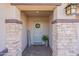 Welcoming front entrance featuring stone pillars, a decorative wreath, and a cozy welcome mat at 12117 W Luxton Ln, Avondale, AZ 85323