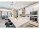 Bright kitchen features a large island with quartz countertop, stainless steel appliances and pendant lighting at 12117 W Luxton Ln, Avondale, AZ 85323