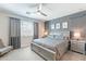 Serene main bedroom with a neutral color palette, ceiling fan, and large window with ample natural light at 12117 W Luxton Ln, Avondale, AZ 85323