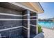 Modern outdoor shower area with sleek gray tiles and convenient grab bars next to the community pool at 12117 W Luxton Ln, Avondale, AZ 85323