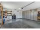 Spacious garage with epoxy flooring, built-in storage cabinets, and shelving units for organization at 12822 W Ballad Dr, Sun City West, AZ 85375