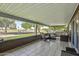 Spacious covered porch area with comfortable seating overlooking a lush green golf course at 12822 W Ballad Dr, Sun City West, AZ 85375
