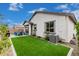 Manicured backyard features lush artificial turf and a covered patio at 14254 W Honeysuckle Dr, Surprise, AZ 85387